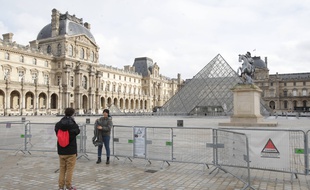 Des touristes devant le musée du Louvre fermé, à Paris le 28 décembre 2020.