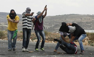Des hommes des services de sécurité israéliens infiltrés arrêtent un Palestinien qui lançait des pierres sur les soldats israéliens et tirent sur des manifestants à Beit El, près de la ville de Ramallah, en Cisjordanie, le 7 octobre 2015