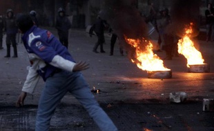 Un manifestant fait face aux forces de l'ordre au Caire le 26 janvier 2011.