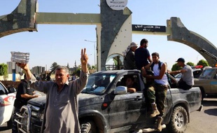 Des combattants islamistes de Fajr Libya montent la garde à l'entrée de l'aéroport de Tripoli le 24 août 2014