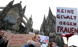 Un homme tient une pancarte "pas de violence contre les femmes" lors d'une manifestation devant la cathédrale de Cologne le 9 janvier 2015