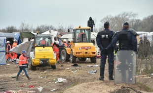 Des policiers surveillent le démantèlement d'abris dans la "jungle" de Calais par des bulldozers, le 1er mars 2016