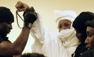 L'ex président tchadien Hissène Habré escorté par des gardiens de prison arrive au tribunal pour le premier jour de son procès à Dakar, le 20 juillet 2015