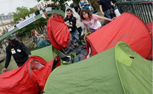 Des membres d'associations d'aide aux sans-abris montent des tentes quai de Valmy à Paris le 9 juin 2014