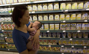 Une femme et son bébé devant du lait infantile en Chine en 2013.