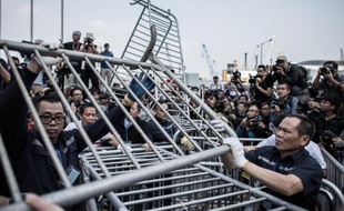 Des agents de sécurité enlèvent des barrières métalliques près d'un camp de manifestants prodémocratie, le 18 novembre 2014 dans le quartier d'Admiralty, à Hong Kong