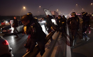 Des CRS interviennent alors que des chauffeurs de VTC en grève bloquent l'autoroute menant à l'aéroport d'Orly, le 17 décembre 2016. AFP PHOTO / Christophe ARCHAMBAULT