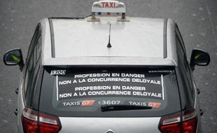 Un taxi affiche sur sa vitre arrière "Profession en danger. Non à la concurrence déloyale", le 15 décembre 2014 à Paris