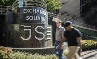 Des gens marchent devant la Bourse de Johannesburg, le 20 mars 2015