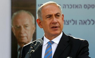 Le Premier ministre israélien Benjamin Netanyahu devant un portrait du Premier ministre assassiné Yitzhak Rabin, lors d'une cérémonie le 16 octobre 2013 au cimetière du Mont Herzel à Jérusalem