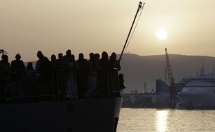 Des migrants attendent de débarquer d'un cargo islandais dans le sud de l'Italie, le 6 mai 2015.