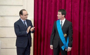Le Premier ministre Manuel Valls (d) reçoit les insignes de la Grand Croix de lOrdre National du Mérite des mains du président François Hollande à l'Elysée à Paris, le 22 octobre 2014