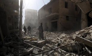 Des Syriens marchent au milieu de débris après un raid aérien à Alep le 7 février 2015