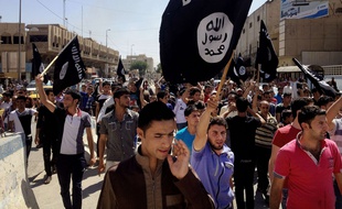 Photo d'archives du 16 juin 2014, montrant des manifestants brandissant le drapeau de Daesh devant le bâtiment du gouvernement de la province de Ninive, à Mossoul, en Irak.