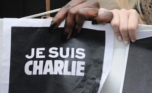 Des personnes tiennent une pancarte "Je suis Charlie" pendant une manifestation en hommage aux victimes des attentats à Paris.