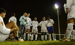 Les joueurs du Paris Football Gay, entourés de leur entraîneur, avant un match de la commission football loisir, face à l'équipe de Champs Elysées.
