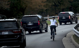 Juli Briskman à vélo face au convoi de Donald Trump qui quitte le golf de Sterling, le 28 octobre 2017.