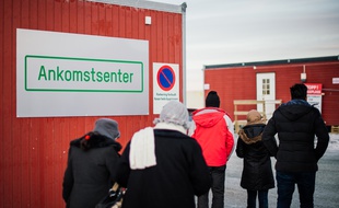 Des réfugiés devant l'entrée d'un centre d'accueil près de Kirkenes, en Norvège, le 12 novembre 2015.