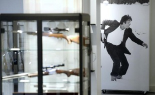 Des armes appartenant à Alain Delon exposées devant une affiche de l'acteur le 28 novembre 2014 à la maison Cornette de Saint Cyr à Paris