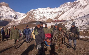 Un randonneur blessé transporté par des soldats népalais dans le district de Manang, près du trekking du tour des Annapurnas, le 15 octobre 2014 dans l'Himalaya