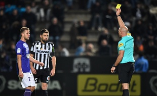 L'arbitre Bartolomeu Varela donne un carton jaune au Toulousain Alexis Blin (à gauche) et à l'Angevin Thomas Mangani lors du match de Ligue 1 à Angers, le 22 octobre 2016.