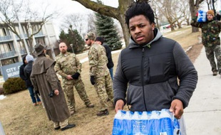 Un étudiant de l'Ohio vient distribuer des bouteilles d'eau aux habitants, à Flint le 24 janvier 2016