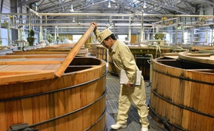 Un salarié vérifie la fermentation du whisky dans la distillerie Suntory Liquor's à Hokuto le 13 mai 2014