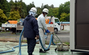 Deux employés travaillent à la décontamination d'un site dans la ville de Naraha, à l'intérieur de la zone d'exclusion autour de la centrale de Fukushima, le 13 juin 2013.