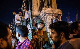 Des soldats turcs en armes sur la place Taksim alors que des personnes protestent contre la tentative de coup d'Etat, à Istanbul, en Turquie, le 16 juillet 2016