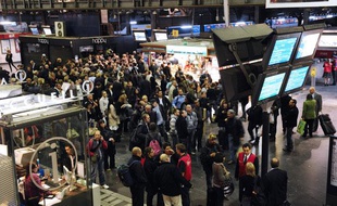 Des usagers de la SNCF rassemblés devant des écrans d'informations, à la gare de l'Est à Paris, alors qu'un mouvement de grève des cheminots a été déclenché à la suite de l'agression d'un contrôleur, le 6 octobre 2011.