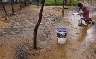 Un enfant joue dans les quartiers de l'ouest de Johannesburg , où des puits d'eau toxique ont débordé, en janvier 2011.