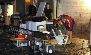 Des personnes évacuent l'eau et la boue de leur maison inondée après de fortes précipitations, le 21 octobre 2009 à Marseille.