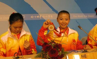 He Kexin, le 13 août, montre sa médaille d’or aux journalistes après avoir remporté l’épreuve de gymnastique artistique.