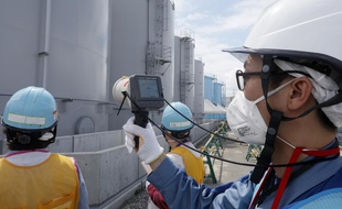 (Illustration) Sur cette photo d'archives prise le 27 juillet 2018, un membre du personnel de Tokyo Electric Power Company mesure les niveaux de rayonnement autour des réservoirs de stockage d'eau contaminée par les radiations à la centrale nucléaire de Fukushima Dai-ichi, du Tokyo Electric Power Company (TEPCO), frappée par le tsunami Okuma, préfecture de Fukushima.