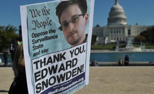 Des manifestants brandissent une affiche en soutien à Edward Snowden à Washington le 26 octobre 2013
