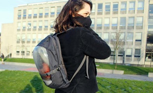 Une jeune femme porte un masque lié à un sac à dos dans lequel se trouve un système de purification d'air à base de plantes, le 18 janvier 2016 à Delft, près de La Haye