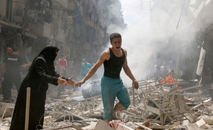 Des habitants d'Alep marchent parmi les décombres après un bombardement, le 28 avril 2016.