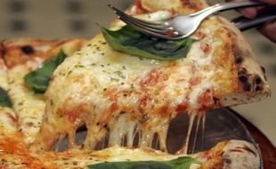 A slice of Margherita pizza is served at Braz pizzeria in Sao Paulo, September 28, 2007. Sao Paulo is home to more than 6,000 pizza parlors that, in all, churn out close to a million pies a day, according to the local association of pizzerias. By some estimates, only New Yorkers devour more pizzas annually than Paulistanos. Picture taken September 28, 2007.