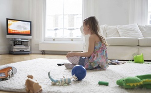 Une petite fille devant la télévision (illustration).