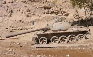 Un hazara passe à côté des vestiges d'un blindé russe le 24 octobre 2012, à Bamiyan, au nord-ouest de Kaboul