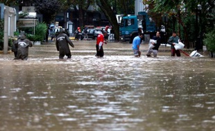 La police aide le 17 avril 2016 les habitants de Santiago, capitale du Chili frappée par de fortes pluies ayant entraîné la crue de la rivière Mapocho