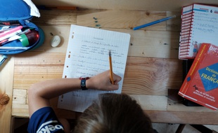 Un enfant qui suit la classe à domicile.