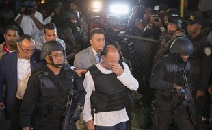 Le Français Christophe Naudin (c), est escorté par des forces de police lors de son arrivée en République Dominicaine, le 4 mars 2016 à Saint-Domingue.