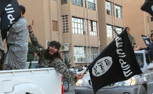 Un membre supposé du groupe Etat islamique paradant un drapeau à la main dans les rues de Raqqa en Syrie le 30 juin 2014. (image d'illustration)