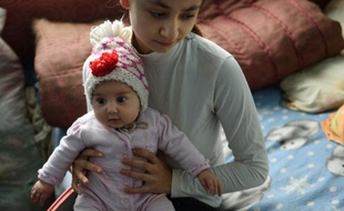 Lorena, 15 ans, et sa fille, dans un bâtiment abandonné où elle habite avec d'autres familles, dans un village près de Botosani, dans le nord-est de la Roumanie, le 30 mars 2016