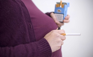 Une femme enceinte tenant un paquet de cigarettes (illustration).