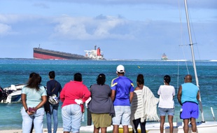 Des Mauriciennes et des Mauriciens observent le navire échoué à proximité du site naturel de Blue Bay, jeudi 6 août 2020.