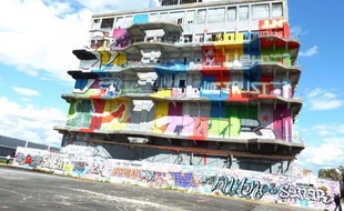 A la bombe de couleur, un graffeur met sa dernière touche au bâtiment des douanes de Pantin: cet entrepôt 1930 désaffecté, qui évoque un paquebot échoué aux portes de Paris, se refait une beauté avant des travaux qui doivent en faire le siège artistique d'une agence de publicité.