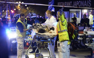 Une victime de l'attaque de la salle du Bataclan à Paris évacué par les services de secours, le 14 novembre 2015