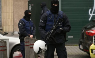 Des policiers lors d'une opération dans le quartier de Molenbeek à Bruxelles le 16 novembre 2015